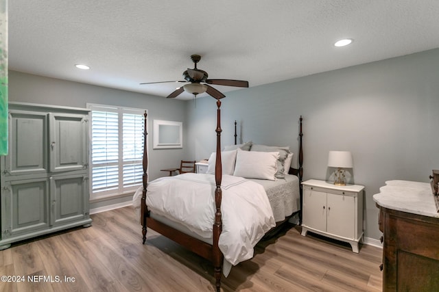 bedroom featuring ceiling fan, wood-type flooring, and a textured ceiling