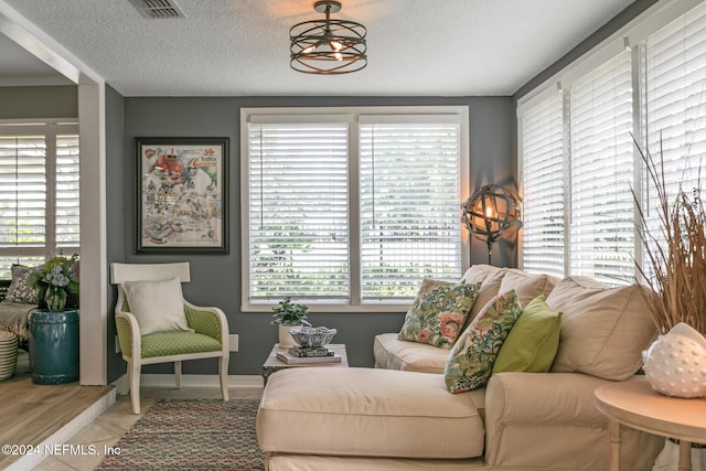 living room featuring a chandelier and a textured ceiling