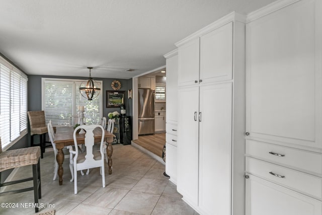 dining space featuring light tile patterned floors, ornamental molding, and a notable chandelier