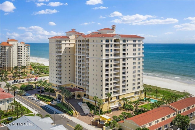 view of building exterior featuring a water view and a view of the beach