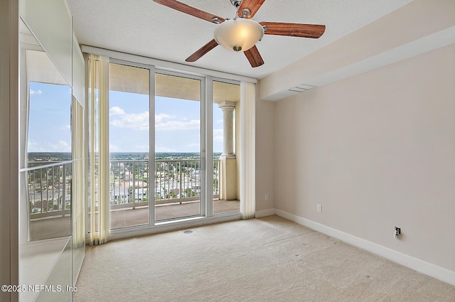 carpeted empty room featuring floor to ceiling windows, ceiling fan, and a textured ceiling