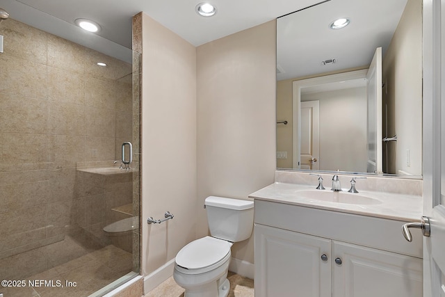 bathroom featuring vanity, a shower with shower door, and toilet