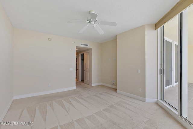 carpeted empty room with ceiling fan and a textured ceiling