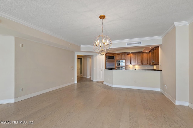 kitchen with light hardwood / wood-style floors, a chandelier, decorative light fixtures, appliances with stainless steel finishes, and ornamental molding