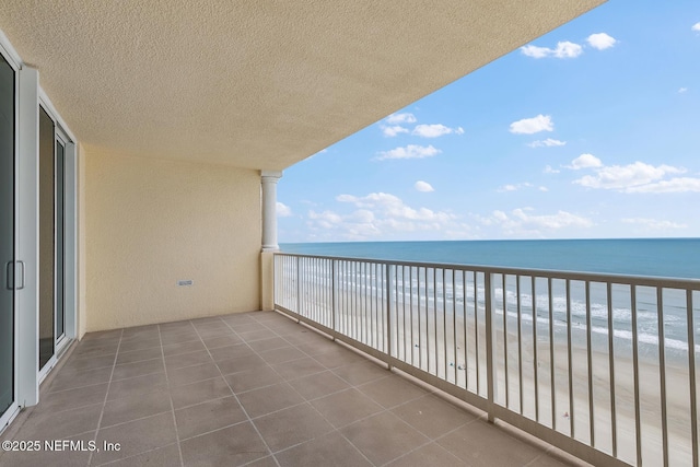 balcony featuring a water view and a view of the beach