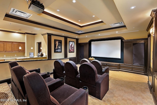 carpeted home theater with a raised ceiling and ornamental molding