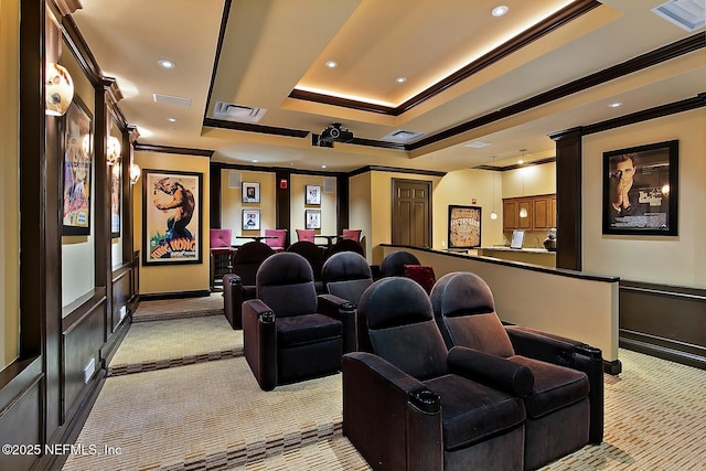 home theater with light colored carpet, a raised ceiling, and crown molding