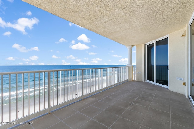 balcony featuring a water view and a view of the beach