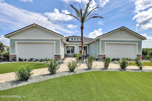 craftsman-style home featuring a front yard, stone siding, and an attached garage