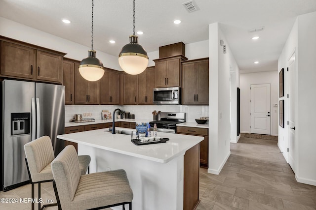 kitchen featuring stainless steel appliances, light countertops, a sink, and tasteful backsplash