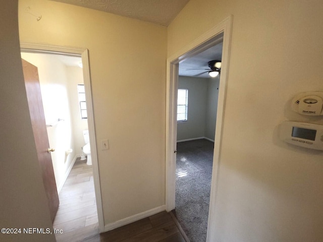 hallway featuring baseboards and wood finished floors