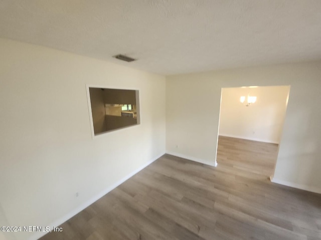 unfurnished room with visible vents, baseboards, and wood finished floors