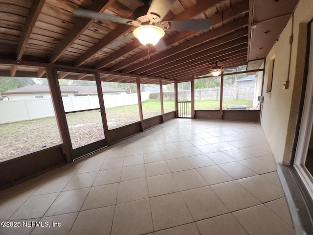 unfurnished sunroom with lofted ceiling with beams, wooden ceiling, and a ceiling fan