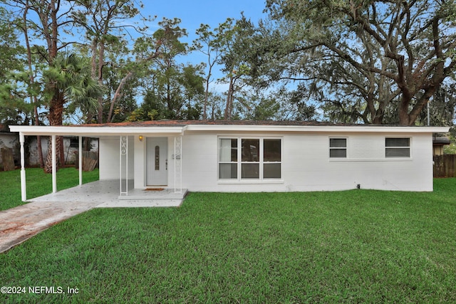 rear view of property with a yard and a carport