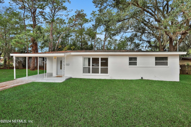 rear view of house featuring a yard and a carport