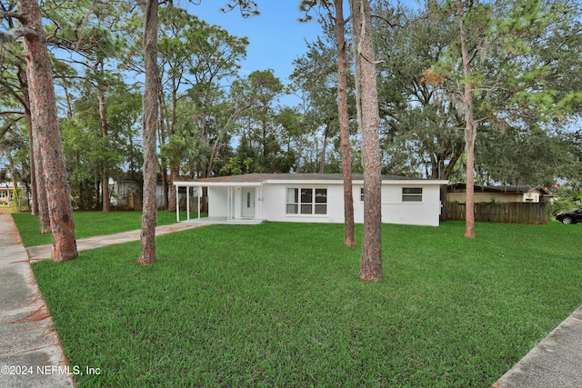 ranch-style home featuring a front yard and a carport