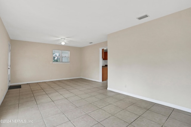 spare room with ceiling fan and light tile patterned flooring