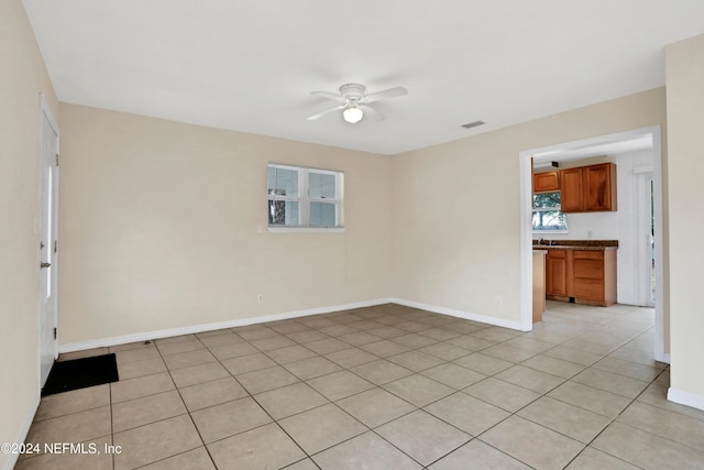 tiled spare room with ceiling fan