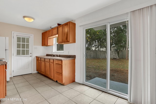 kitchen with plenty of natural light, light tile patterned floors, and sink