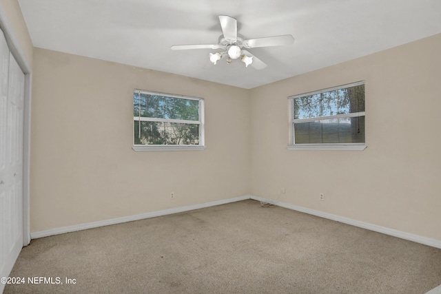 spare room with ceiling fan and light carpet