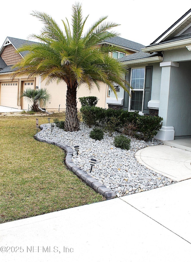 view of home's exterior with a garage and a yard