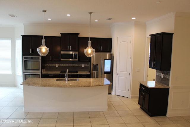 kitchen featuring pendant lighting, light stone countertops, an island with sink, light tile patterned flooring, and stainless steel appliances