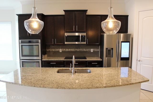 kitchen featuring light stone countertops, sink, tasteful backsplash, a kitchen island with sink, and appliances with stainless steel finishes