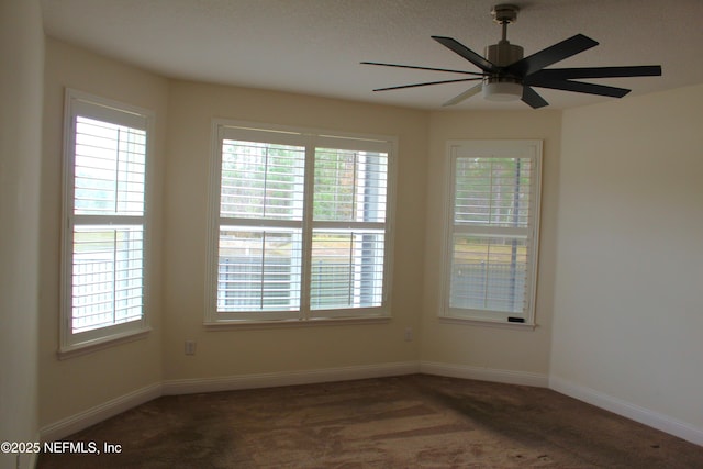 carpeted spare room featuring plenty of natural light and ceiling fan