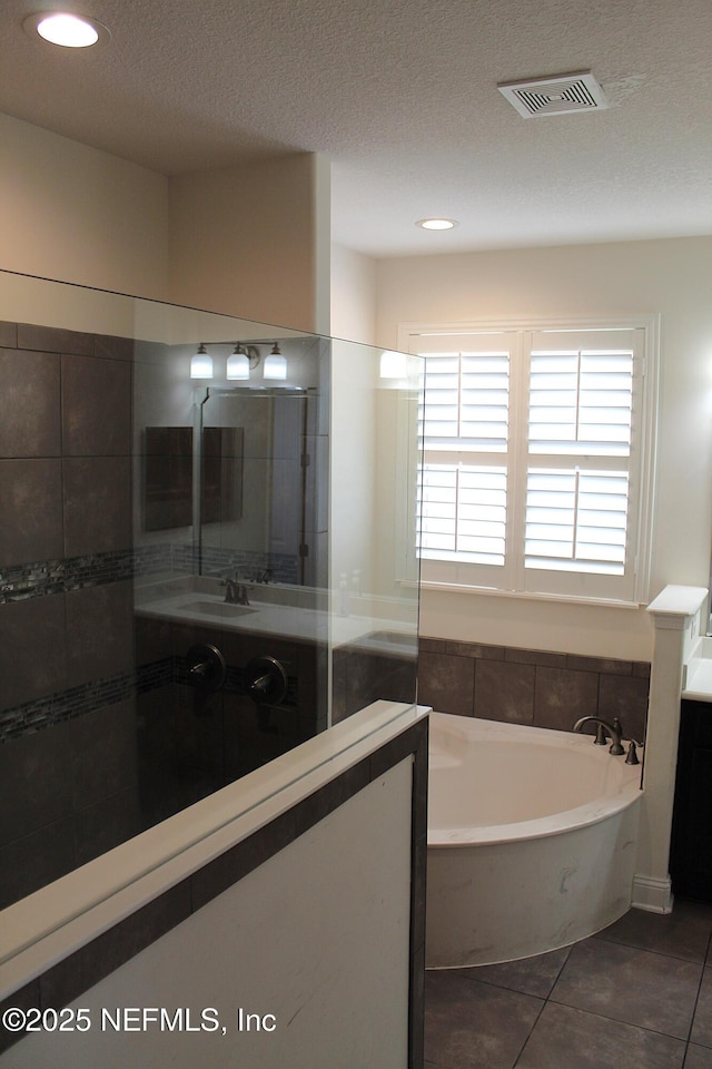 bathroom featuring tile patterned flooring, sink, a textured ceiling, and independent shower and bath