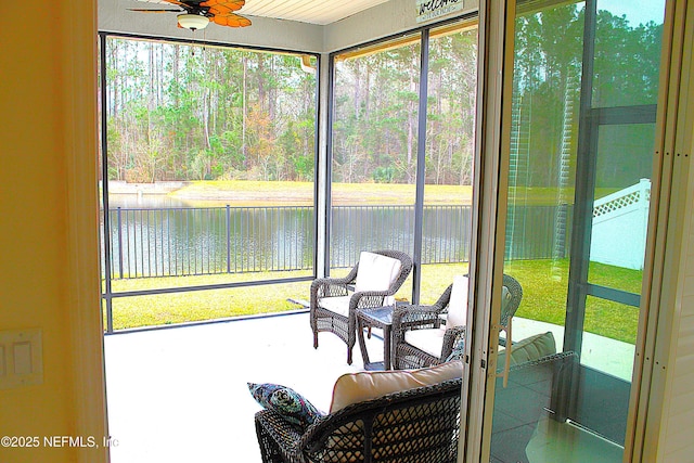 sunroom / solarium featuring ceiling fan and a water view