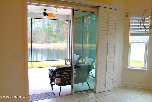 entryway featuring ceiling fan, a water view, and light tile patterned floors