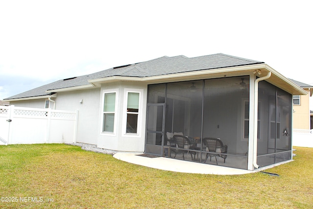 back of property with a lawn and a sunroom