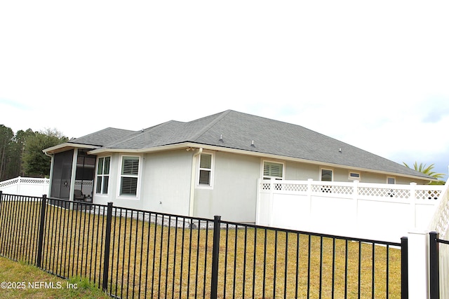 view of side of property with a lawn and a sunroom