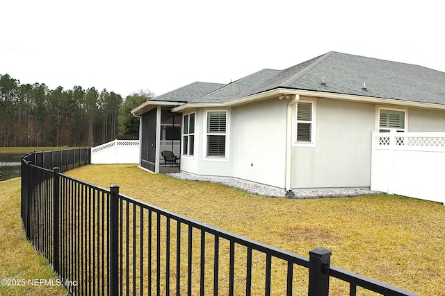 view of side of property featuring a lawn and a sunroom