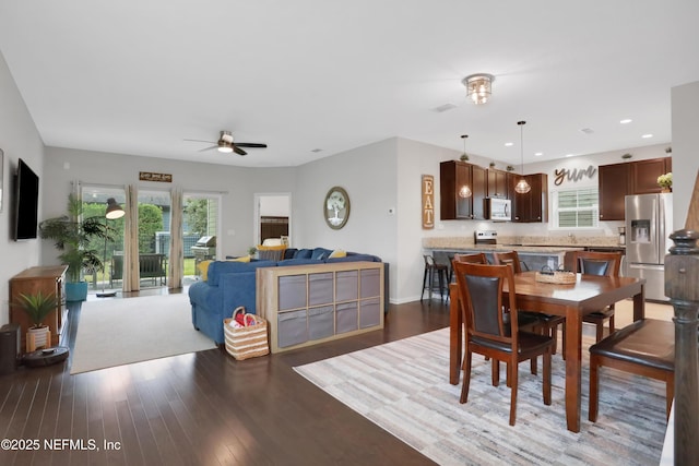 dining space featuring ceiling fan and dark wood-type flooring