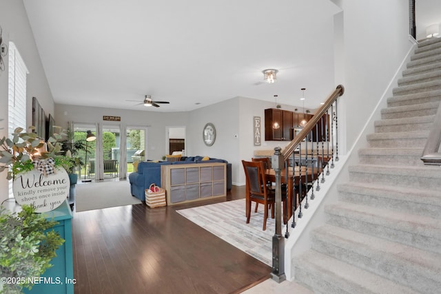 staircase featuring ceiling fan and hardwood / wood-style floors