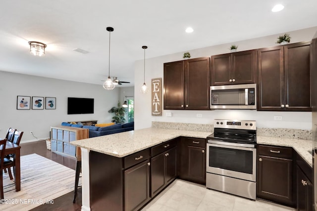 kitchen with kitchen peninsula, stainless steel appliances, decorative light fixtures, and dark brown cabinetry