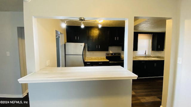 kitchen with dark wood-type flooring, sink, ceiling fan, kitchen peninsula, and stainless steel appliances