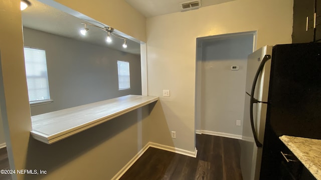 kitchen with black fridge, plenty of natural light, and dark wood-type flooring