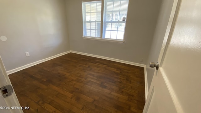 empty room with dark hardwood / wood-style flooring