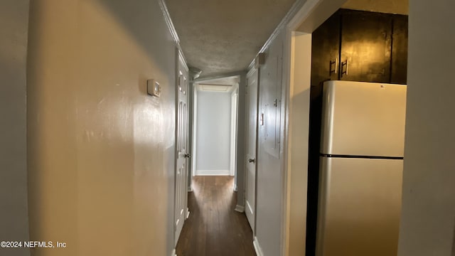 hall with dark hardwood / wood-style flooring, a textured ceiling, and ornamental molding