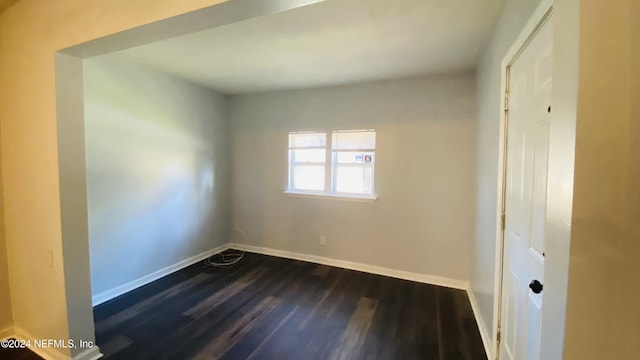 spare room with dark wood-type flooring