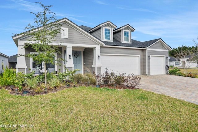 view of front of house featuring covered porch, a garage, and a front lawn