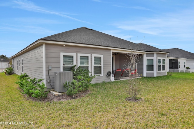 rear view of house featuring a lawn and cooling unit