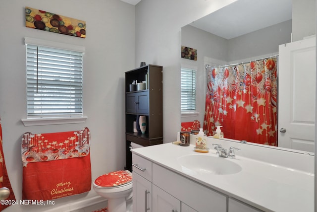 bathroom with curtained shower, vanity, and toilet