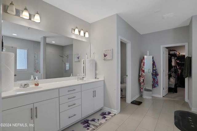 bathroom with vanity, toilet, and a shower with door