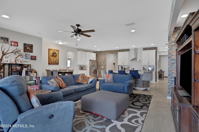 living room featuring ceiling fan and light hardwood / wood-style flooring