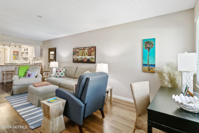 living room featuring light hardwood / wood-style flooring and a textured ceiling