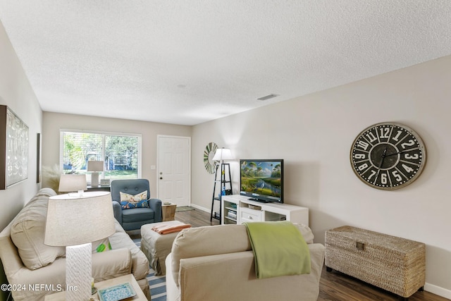 living room featuring dark hardwood / wood-style flooring and a textured ceiling