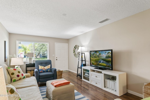 living room with a textured ceiling and dark wood-type flooring